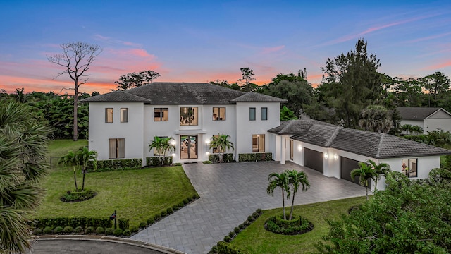 mediterranean / spanish house featuring a yard and a garage