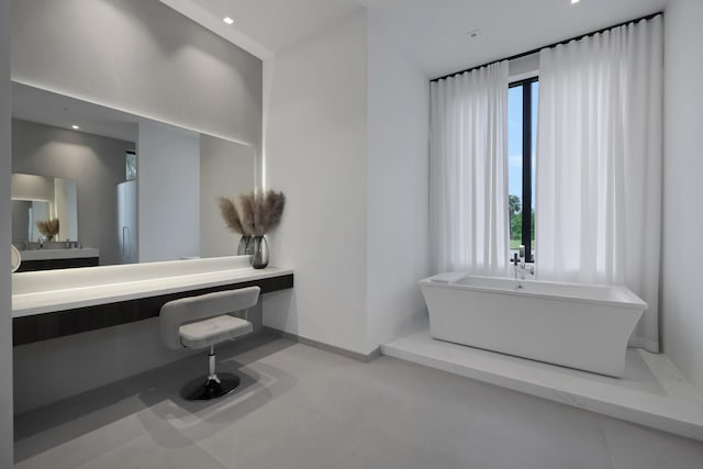 bathroom with a bathtub, vanity, and concrete flooring