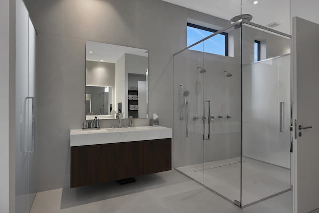 bathroom featuring tile patterned flooring, vanity, and a shower with shower door