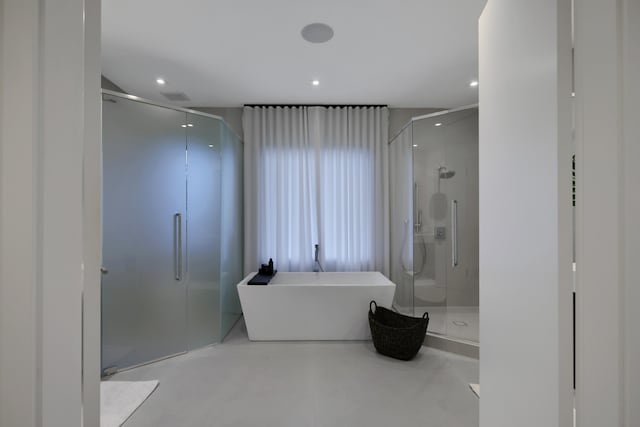 bathroom featuring plus walk in shower and concrete flooring