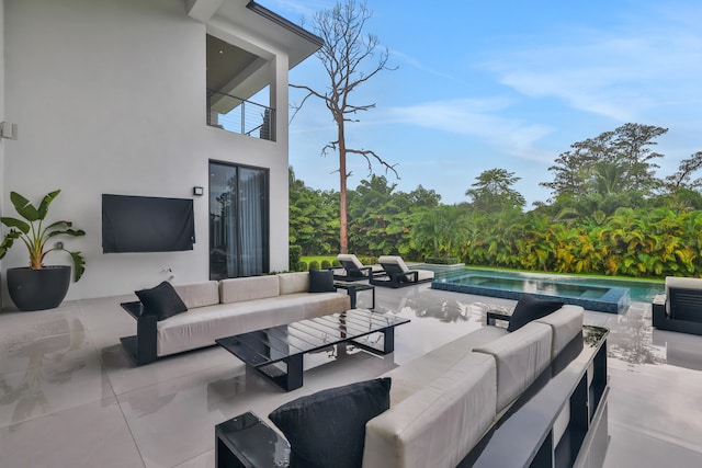 view of patio with an outdoor living space, a pool with hot tub, and a balcony