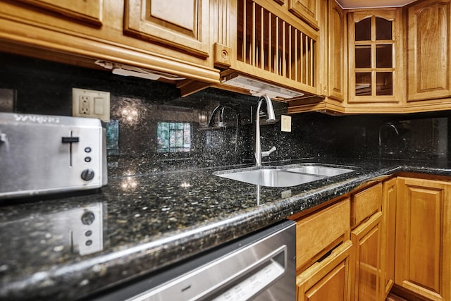 kitchen featuring decorative backsplash, sink, dishwasher, and dark stone countertops