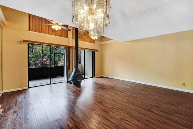 spare room featuring hardwood / wood-style floors, ceiling fan with notable chandelier, a textured ceiling, and a high ceiling