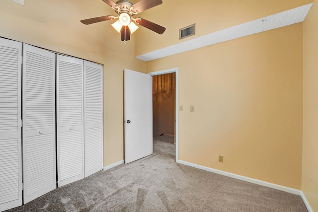 unfurnished bedroom featuring ceiling fan, light carpet, and a closet