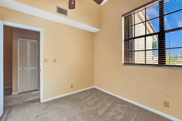 empty room featuring ceiling fan and carpet floors