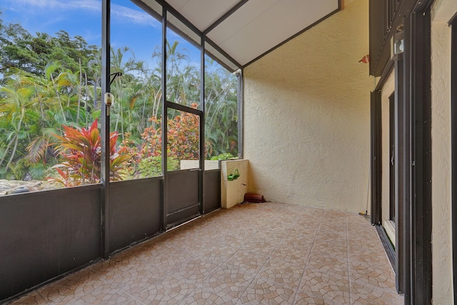 unfurnished sunroom featuring a healthy amount of sunlight and vaulted ceiling