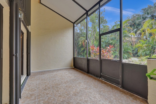 unfurnished sunroom featuring vaulted ceiling