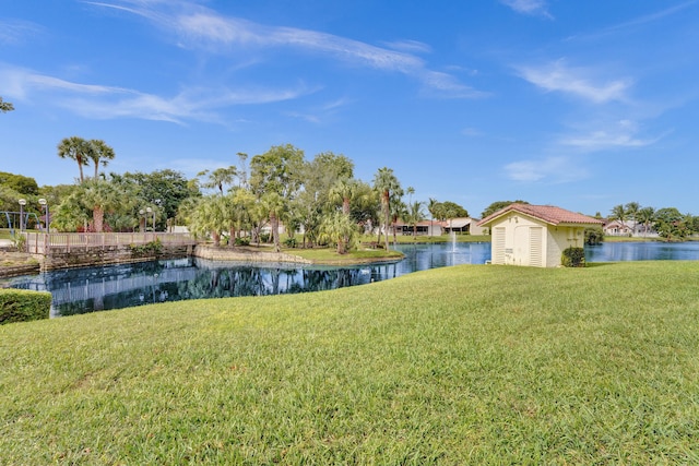 view of yard with a water view and an outbuilding