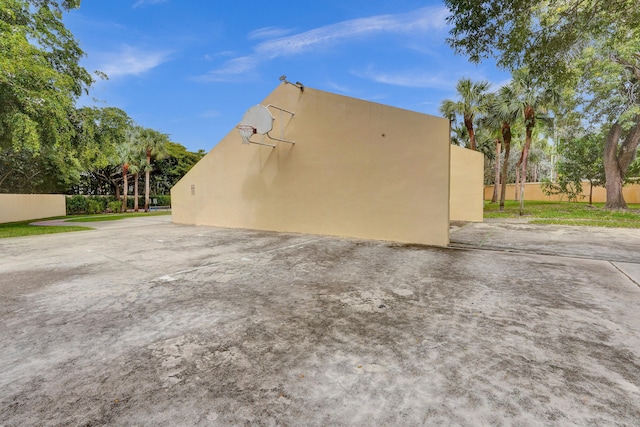 view of property exterior with basketball hoop