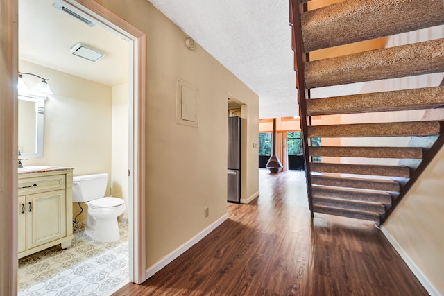 hall with dark hardwood / wood-style flooring and a textured ceiling