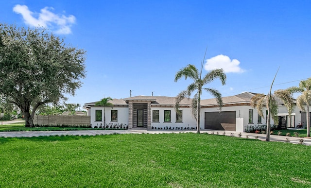 ranch-style house featuring a front lawn and a garage