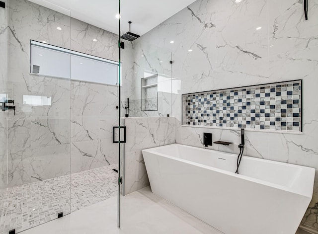 bathroom with shower with separate bathtub and tile walls