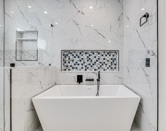 bathroom featuring tile walls and a tub