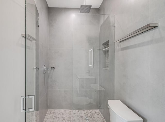 bathroom featuring toilet and a shower with shower door