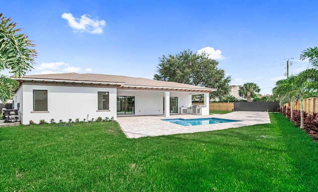 back of property with area for grilling, a patio area, and a yard