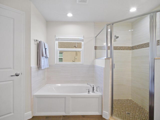 bathroom featuring separate shower and tub