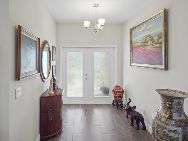 entrance foyer with french doors, dark hardwood / wood-style floors, and an inviting chandelier