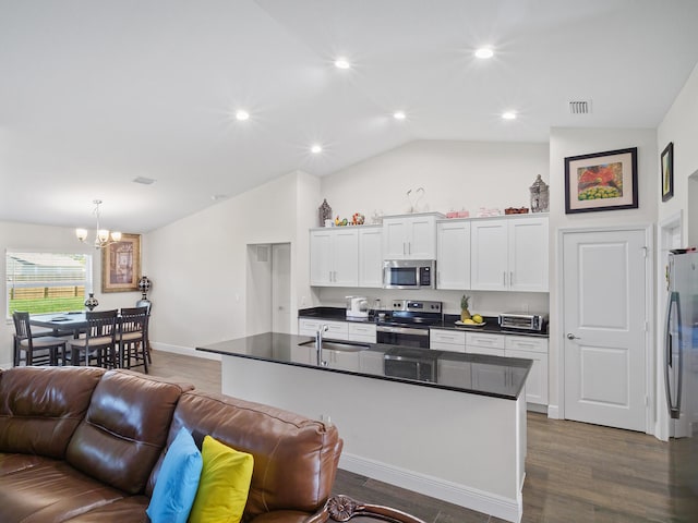 kitchen with hanging light fixtures, dark hardwood / wood-style flooring, vaulted ceiling, white cabinets, and appliances with stainless steel finishes