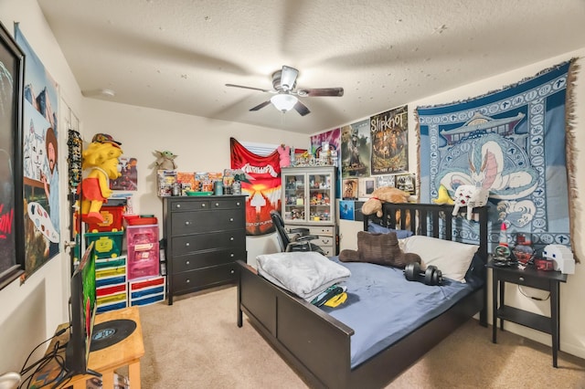 bedroom featuring ceiling fan, light colored carpet, and a textured ceiling