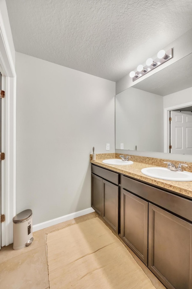 bathroom featuring vanity, a textured ceiling, and tile patterned flooring