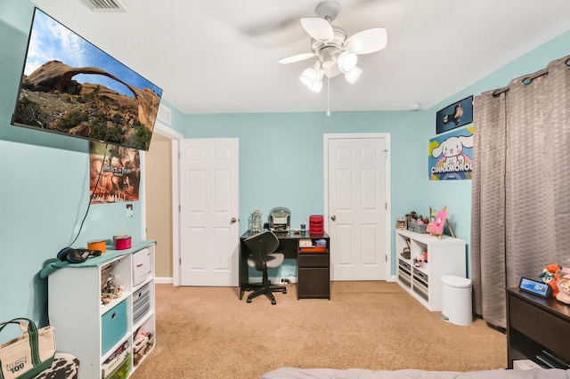 carpeted home office featuring ceiling fan