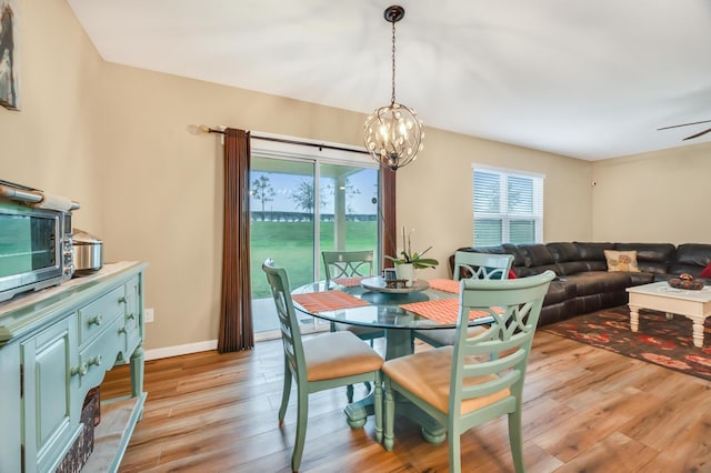 dining space featuring ceiling fan with notable chandelier and light hardwood / wood-style floors