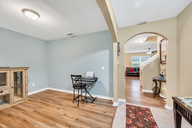 interior space with hardwood / wood-style floors, ceiling fan, and a textured ceiling