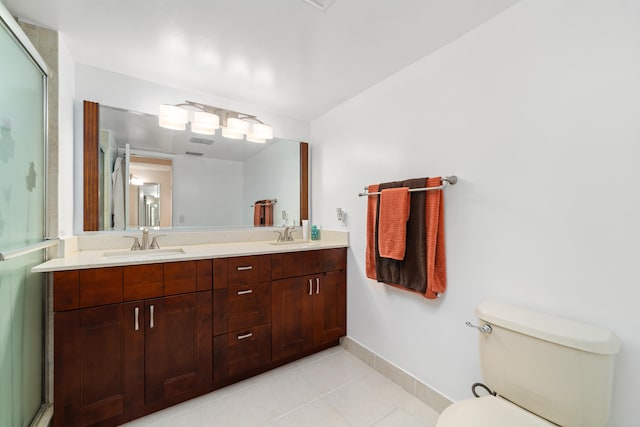 bathroom with tile patterned flooring, vanity, toilet, and a shower with door