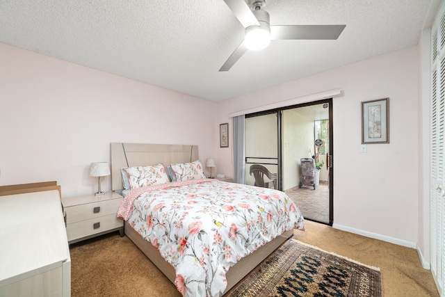 bedroom with a closet, a textured ceiling, light colored carpet, and ceiling fan