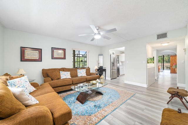 7579 NW 79th Ave Unit 201, Tamarac, FL 33321 - living area featuring a ceiling fan, visible vents, arched walkways, baseboards, and light wood-style floors