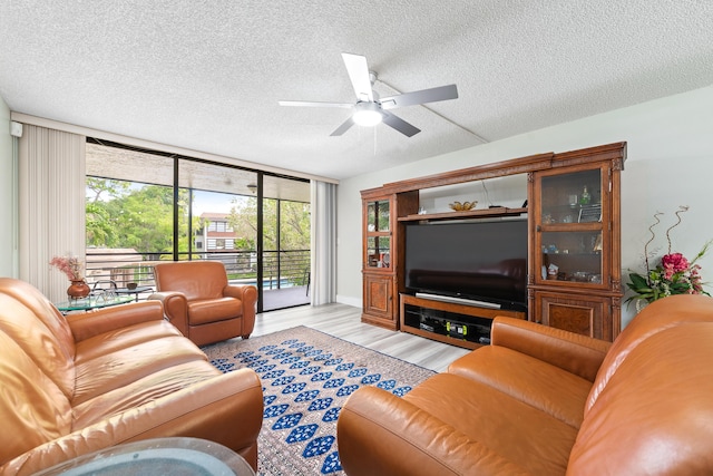 7579 NW 79th Ave Unit 201, Tamarac, FL 33321 - living room featuring expansive windows, light wood-style flooring, a textured ceiling, and ceiling fan