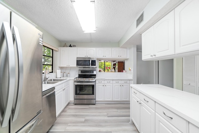 7579 NW 79th Ave Unit 201, Tamarac, FL 33321 - kitchen featuring a textured ceiling, visible vents, appliances with stainless steel finishes, a sink, and light countertops