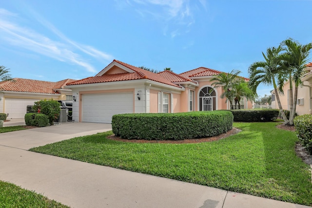 mediterranean / spanish-style house with a garage, a front yard, and central air condition unit