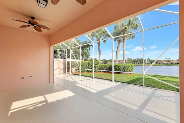 unfurnished sunroom with ceiling fan and a water view