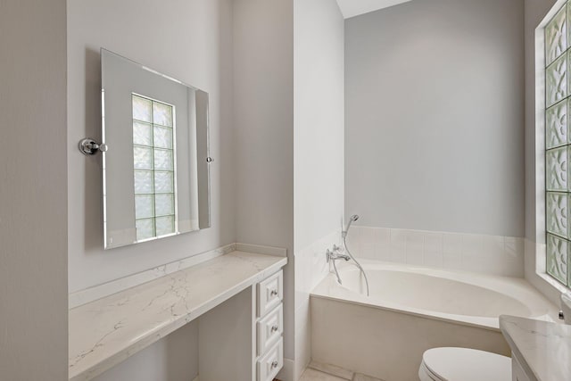 bathroom with toilet, vanity, and a tub