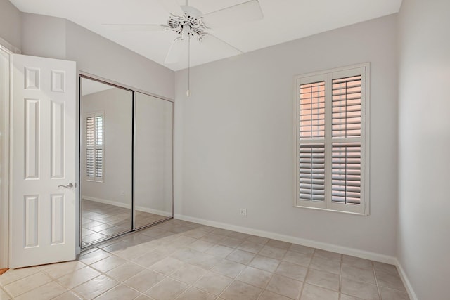 unfurnished bedroom with ceiling fan, light tile patterned floors, and a closet