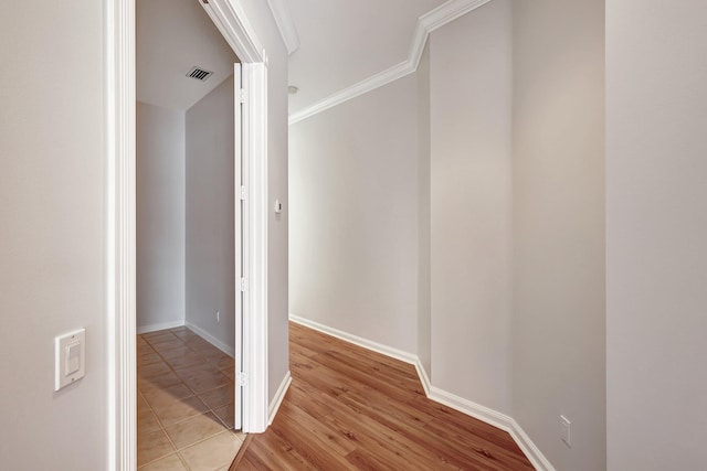 hallway with light tile patterned flooring and ornamental molding