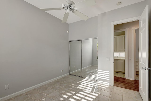 unfurnished bedroom featuring ceiling fan, a closet, and light tile patterned flooring