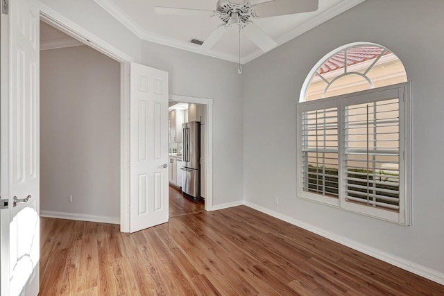 unfurnished bedroom featuring ceiling fan, ornamental molding, wood-type flooring, and high end fridge