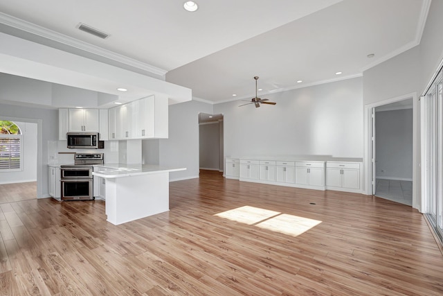 kitchen featuring light wood-type flooring, ceiling fan, appliances with stainless steel finishes, and white cabinetry