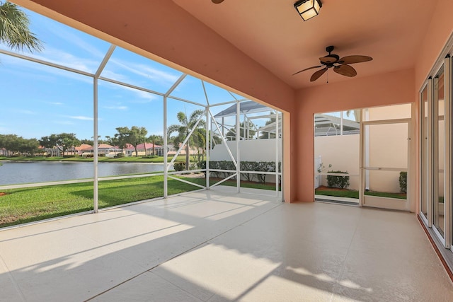 unfurnished sunroom featuring a water view and ceiling fan