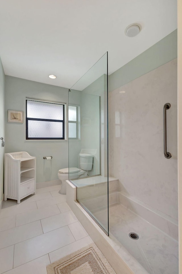 bathroom featuring tile patterned floors, a tile shower, and toilet