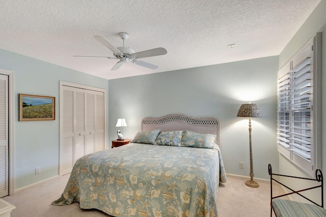 carpeted bedroom with a textured ceiling, a closet, and ceiling fan