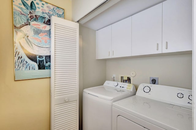 washroom featuring cabinets and independent washer and dryer