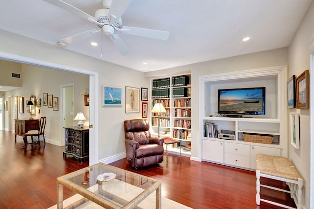 living room featuring dark hardwood / wood-style floors, ceiling fan, a textured ceiling, and built in shelves