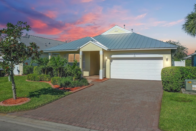 view of front of home with a lawn and a garage