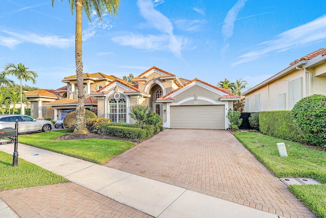 mediterranean / spanish-style home featuring a garage and a front lawn