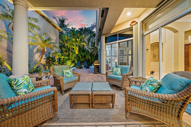 patio terrace at dusk featuring an outdoor hangout area