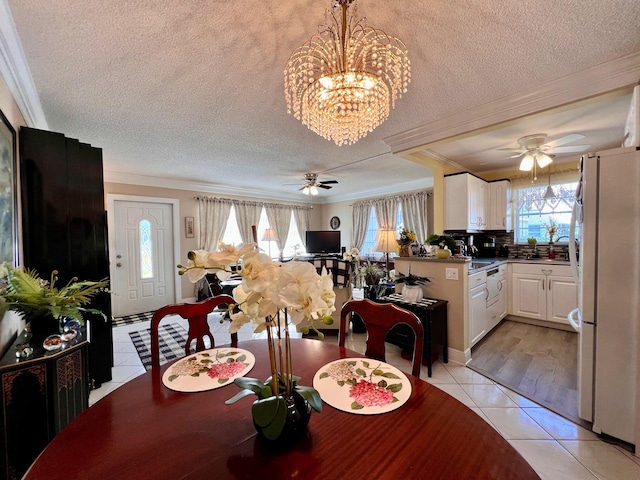 dining area featuring a textured ceiling, ceiling fan with notable chandelier, light tile patterned floors, and ornamental molding