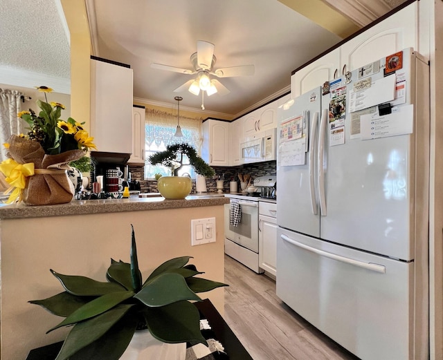 kitchen with white cabinets, white appliances, light hardwood / wood-style flooring, and ornamental molding